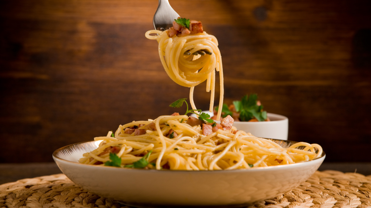 A plate of pasta with cheese and sauce.