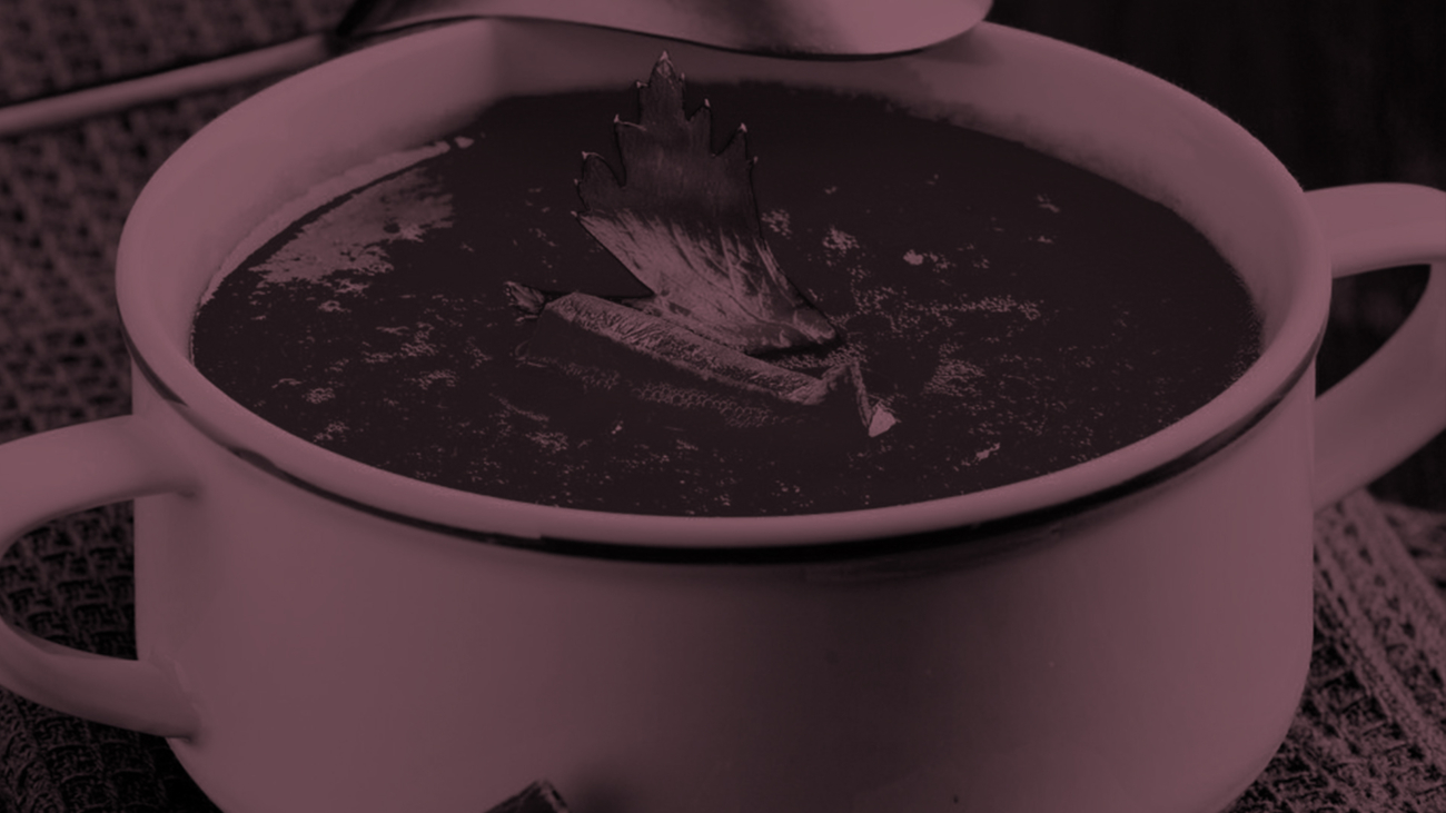 A pot of soup with a spoon in it.