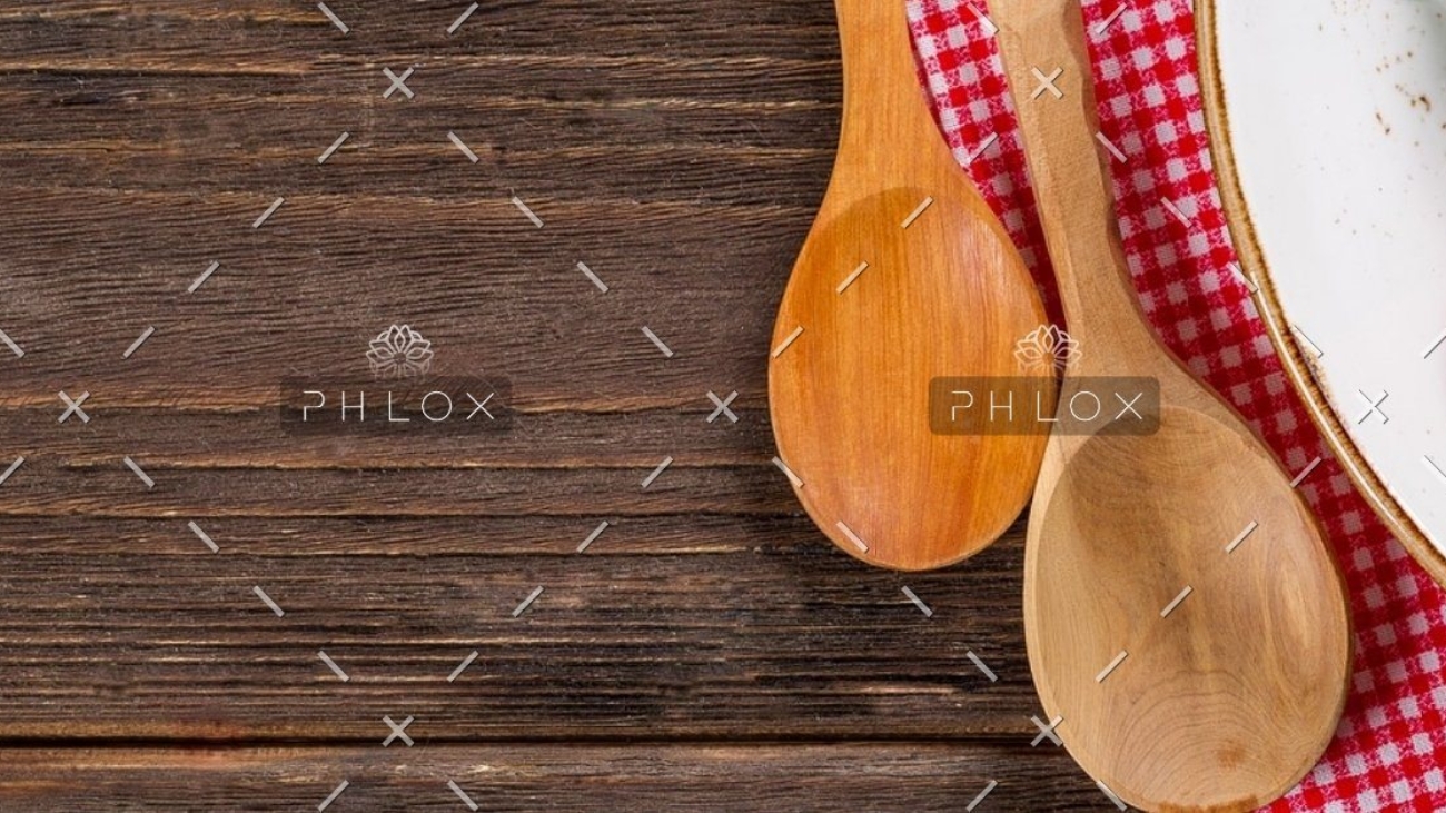 A wooden spoon and fork on top of a table.